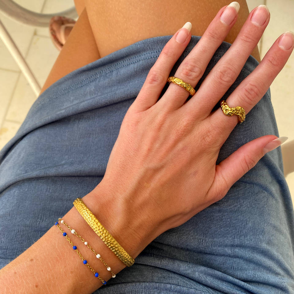 Guldringe og armbånd på kvindearm