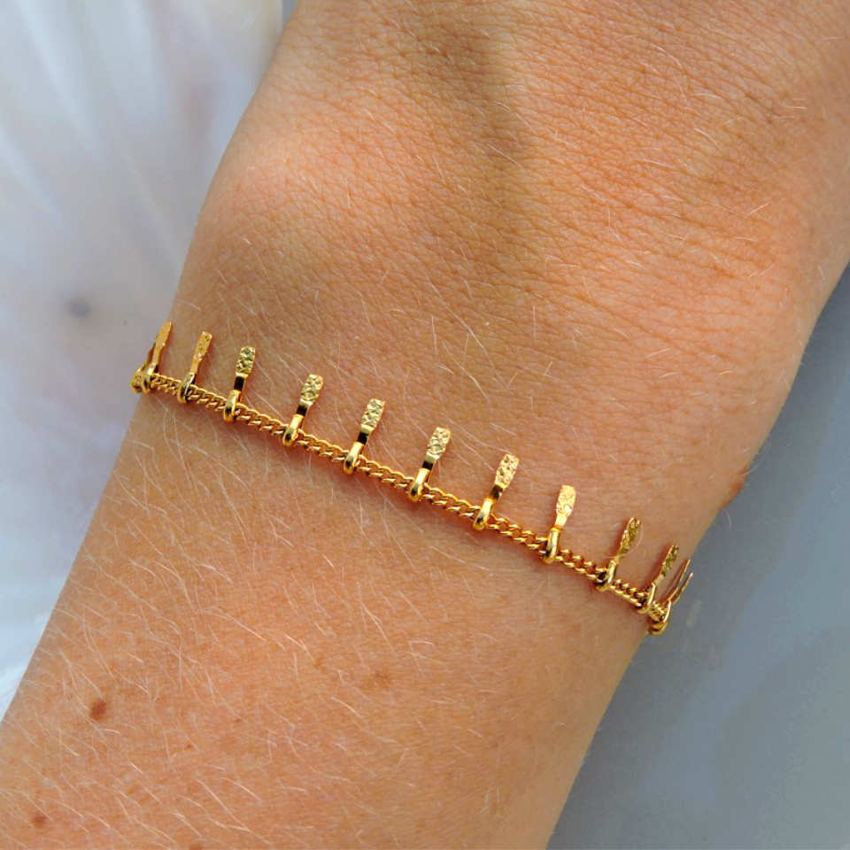 Guld armbånd med detaljer på håndled
