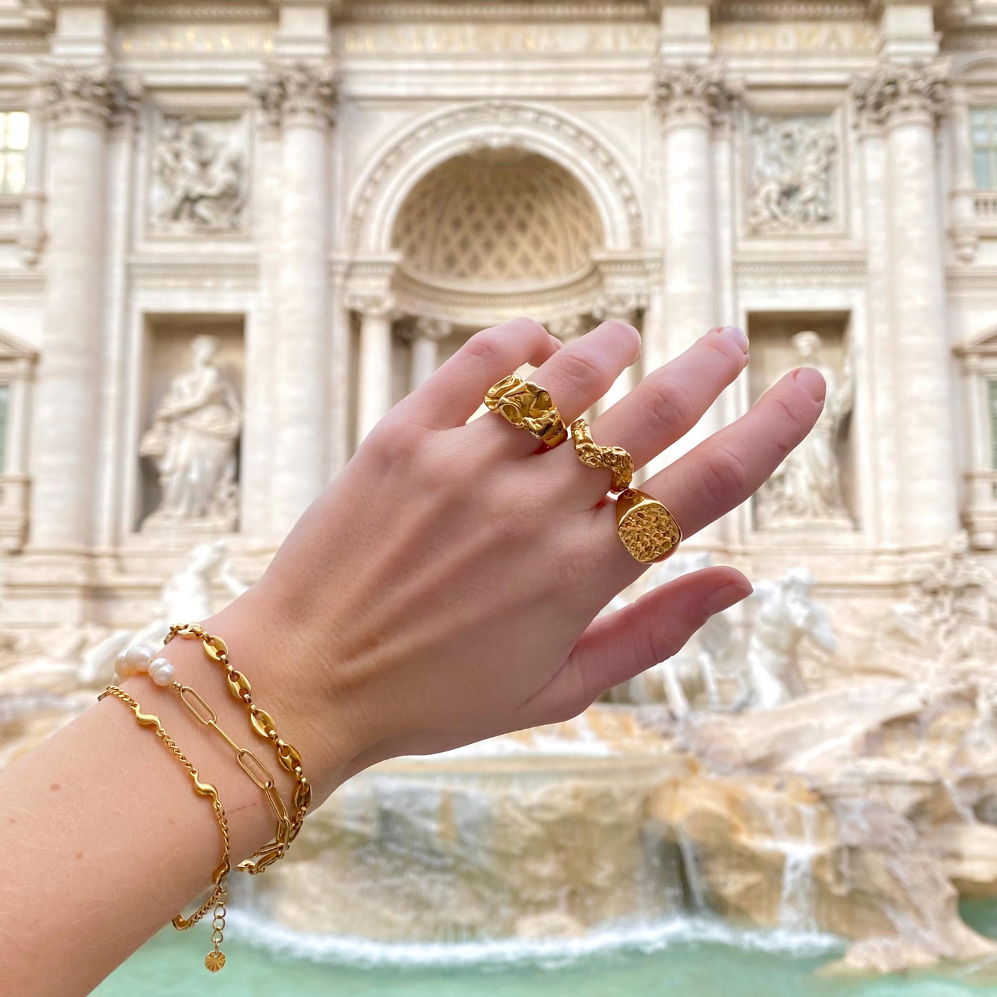 Astrapi vandfast guldarmbånd stylet blandt armbånd